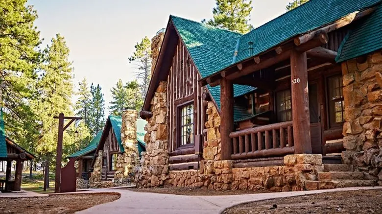 Exterior view of Bryce Canyon Lodge. Wood wallks meet green metal roofing to give a rustic feel.